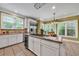 Bright kitchen with large windows, white cabinets, stainless appliances and a central island for food prep and dining at 7212 Avalon Dr, Douglasville, GA 30135
