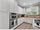 Well-equipped kitchen featuring stainless steel oven, neutral counter tops, and ample white cabinetry, a perfect culinary space at 7212 Avalon Dr, Douglasville, GA 30135