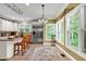 Bright kitchen featuring white cabinets, stainless steel appliances, breakfast bar, and ample counter space with a view to the outside at 7212 Avalon Dr, Douglasville, GA 30135