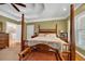 Charming main bedroom features a four-poster bed, hardwood floors, tray ceiling, and neutral paint at 7212 Avalon Dr, Douglasville, GA 30135