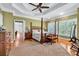 Bright main bedroom with hardwood floors, a four-poster bed, ceiling fan, and multiple windows at 7212 Avalon Dr, Douglasville, GA 30135
