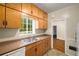 Kitchen featuring laminate counters, wood cabinetry, and stainless steel sink at 1981 N Decatur Ne Rd, Atlanta, GA 30307