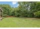 Lush green backyard with mature trees and a wooden fence providing privacy at 4591 Millstone Walk Ne Dr, Buford, GA 30519