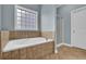 Bright bathroom featuring a tub, tile surround, shower and blue walls at 4591 Millstone Walk Ne Dr, Buford, GA 30519