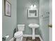 Small bathroom with a pedestal sink, toilet, and green painted walls at 4591 Millstone Walk Ne Dr, Buford, GA 30519