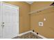 A laundry room with a shelf, white door, and tan painted walls at 4591 Millstone Walk Ne Dr, Buford, GA 30519