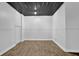 Room with metal ceilings, laminate floors, white wainscotting and a door at 4591 Millstone Walk Ne Dr, Buford, GA 30519