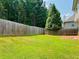 A lush backyard with a tall privacy fence, green grass, and mature trees, ideal for outdoor activities and relaxation at 5123 Upper Elm St, Atlanta, GA 30349