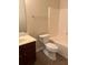 Neutral bathroom featuring a white toilet, tub and a dark wood vanity at 5123 Upper Elm St, Atlanta, GA 30349