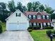Charming two-story home with a brick and siding exterior, attached two-car garage, and manicured lawn at 5123 Upper Elm St, Atlanta, GA 30349