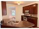 Modern kitchen with dark wood cabinets, granite countertops, stainless steel appliances, and an island sink at 5123 Upper Elm St, Atlanta, GA 30349