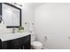 Bathroom featuring a dark vanity with white countertop, toilet, and mirror at 6 Stratford Hall Ne Pl, Atlanta, GA 30342