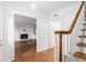 Inviting entryway featuring hardwood floors, staircase and an opening into the living room with a fireplace at 6 Stratford Hall Ne Pl, Atlanta, GA 30342