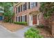 Charming brick townhome with black shutters, a red door, and lush landscaping at 6 Stratford Hall Ne Pl, Atlanta, GA 30342