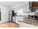 Modern kitchen featuring stainless steel appliances, granite countertops, and light wood floors at 6 Stratford Hall Ne Pl, Atlanta, GA 30342