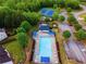 Aerial view of community with pool, tennis courts and wooded areas at 895 Roxfield Ct, Buford, GA 30518