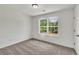 Sunlit bedroom features neutral carpet, a large window with bright white trim and ship lap accent wall at 895 Roxfield Ct, Buford, GA 30518