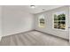Bright bedroom with neutral carpet and two large windows at 895 Roxfield Ct, Buford, GA 30518
