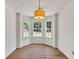 Bright dining room with hardwood floors, three windows, and a modern chandelier at 895 Roxfield Ct, Buford, GA 30518
