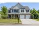 Charming two-story home with a well-manicured lawn and a two-car garage at 895 Roxfield Ct, Buford, GA 30518