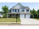 Traditional two-story home with a two-car garage and well-manicured lawn at 895 Roxfield Ct, Buford, GA 30518