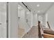 Hallway with carpeted floors and white trim features a barn door to the laundry room at 895 Roxfield Ct, Buford, GA 30518
