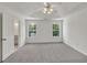 Open bedroom with carpeted floors and a view of the backyard from two large windows at 895 Roxfield Ct, Buford, GA 30518