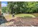 Expansive backyard with lush green grass, mature trees, and a patio area at 1828 Brandy Woods Se Dr, Conyers, GA 30013