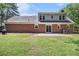 Spacious backyard featuring a lush lawn, brick house exterior, and sliding glass doors to the patio at 1828 Brandy Woods Se Dr, Conyers, GA 30013