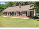 Charming brick home with a well-manicured front lawn and mature landscaping at 1828 Brandy Woods Se Dr, Conyers, GA 30013