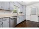 Kitchen features stainless steel dishwasher, gray cabinets, window, and exterior door with blinds at 1828 Brandy Woods Se Dr, Conyers, GA 30013