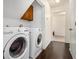 Neat laundry room with modern washer and dryer, wood floors, and storage area at 1828 Brandy Woods Se Dr, Conyers, GA 30013