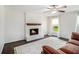 Inviting living room with a brick fireplace, ceiling fan, hardwood floors, and large windows at 1828 Brandy Woods Se Dr, Conyers, GA 30013