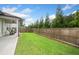An expansive backyard is enclosed by a privacy fence and features lush green grass and a covered back porch at 209 Floral Valley Dr, Woodstock, GA 30188