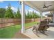 Relaxing backyard patio with ceiling fan, rocking chairs, and a well-maintained lawn at 209 Floral Valley Dr, Woodstock, GA 30188