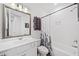 Well-lit bathroom with a modern vanity, framed mirror, a bathtub with shower, and stylish towel racks at 209 Floral Valley Dr, Woodstock, GA 30188