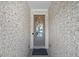 Inviting front entryway featuring a glass-paneled door, brick walls and a stylish 