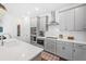Bright kitchen boasts gray cabinets, stainless appliances, ample counter space, and stylish design elements at 209 Floral Valley Dr, Woodstock, GA 30188