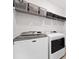 The laundry room features shelving and side-by-side modern washer and dryer with a clean, bright finish at 209 Floral Valley Dr, Woodstock, GA 30188