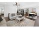 Open-concept living space with hardwood floors, ceiling fan, and abundant natural light flowing into the modern kitchen at 209 Floral Valley Dr, Woodstock, GA 30188