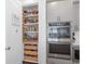 Spacious pantry with organized shelving and pull out drawers, situated next to modern, stainless steel appliances at 209 Floral Valley Dr, Woodstock, GA 30188