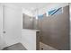 This modern shower offers gray tile walls, stylish fixtures, a glass partition, and a unique floor design at 209 Floral Valley Dr, Woodstock, GA 30188