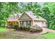 Side view of the property highlighting the garage, driveway, and mature trees at 324 Kibbee Rd, Mcdonough, GA 30252