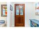 Elegant wooden front door featuring decorative glass panels, complemented by colorful artwork at 324 Kibbee Rd, Mcdonough, GA 30252
