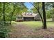 Inviting home with a large front lawn and screened-in porch, nestled among mature trees at 324 Kibbee Rd, Mcdonough, GA 30252