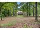 Secluded home surrounded by lush greenery, featuring a spacious front yard and a screened porch at 324 Kibbee Rd, Mcdonough, GA 30252