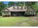 Charming home featuring a well-manicured lawn, inviting screened-in porch, and classic architectural details at 324 Kibbee Rd, Mcdonough, GA 30252