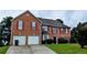 Traditional brick home featuring a two-car garage, shutters, and well-maintained landscaping at 4373 Abram Dr, Conley, GA 30288