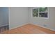Cozy bedroom with hardwood floors, neutral walls, and a window overlooking the outdoor greenery at 622 Sheffield Rd, Norcross, GA 30071