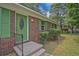 Close-up of a brick home featuring a green front door and shutters adding character and curb appeal at 622 Sheffield Rd, Norcross, GA 30071
